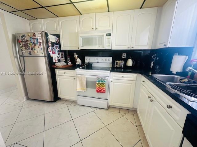 kitchen with sink, white cabinets, and white appliances