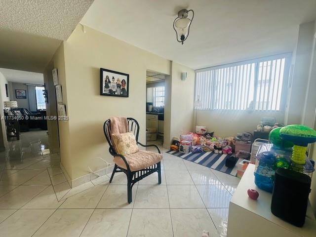 sitting room with light tile patterned flooring and a healthy amount of sunlight