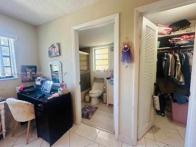 bathroom with tile patterned floors, toilet, and a textured ceiling