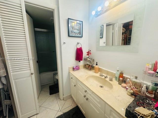 bathroom with vanity, an enclosed shower, and tile patterned flooring