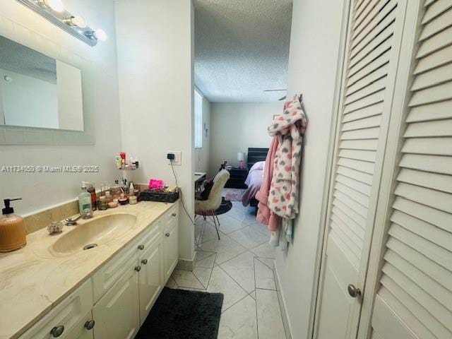 bathroom with vanity, tile patterned flooring, and a textured ceiling