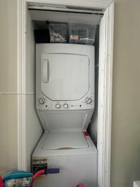 washroom featuring stacked washer / drying machine