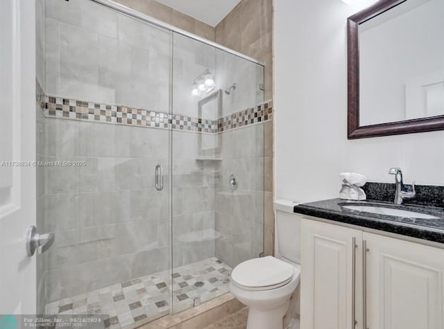 bathroom with walk in shower, vanity, and toilet