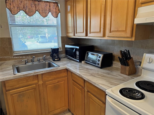 kitchen with tasteful backsplash, white range with electric cooktop, and sink