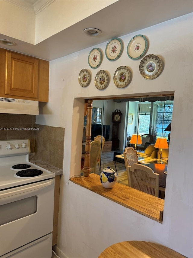 kitchen with electric stove, decorative backsplash, and ornamental molding