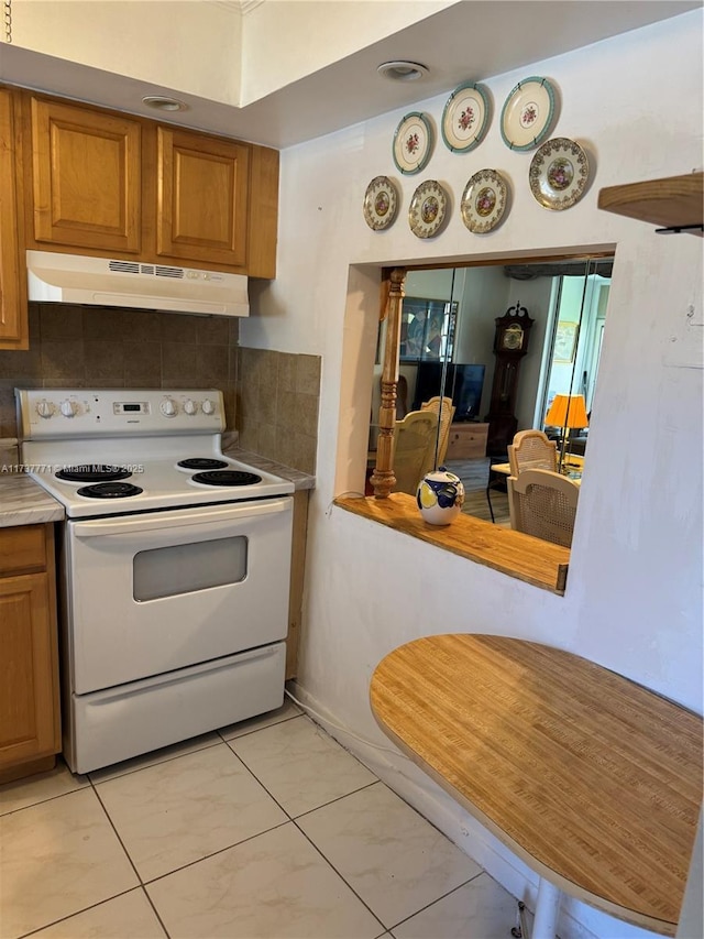 kitchen featuring white electric range and backsplash