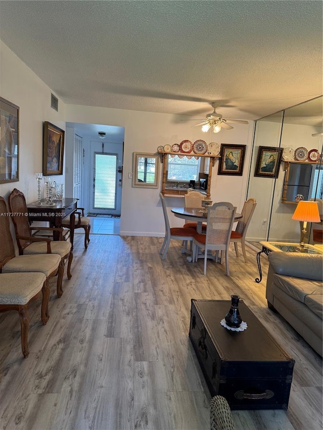 living room with ceiling fan, hardwood / wood-style floors, and a textured ceiling