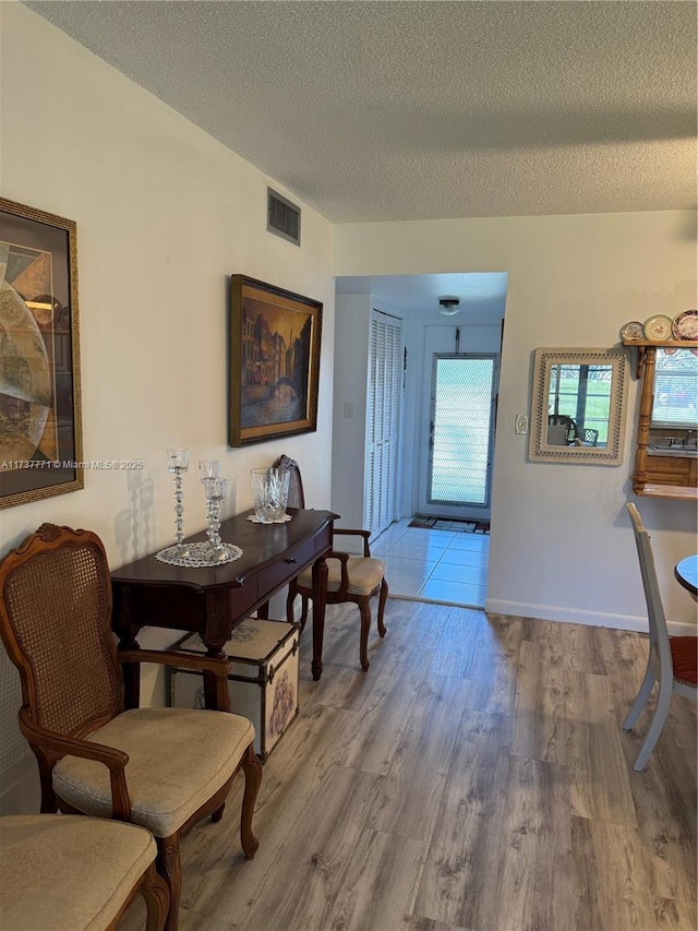 dining room with a textured ceiling and light hardwood / wood-style floors