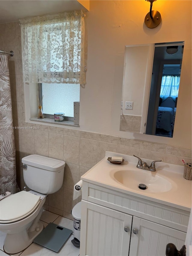 bathroom featuring tile walls, vanity, curtained shower, tile patterned floors, and toilet