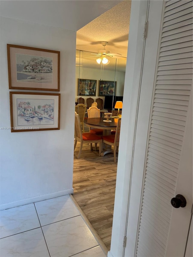 hallway with hardwood / wood-style floors and a textured ceiling