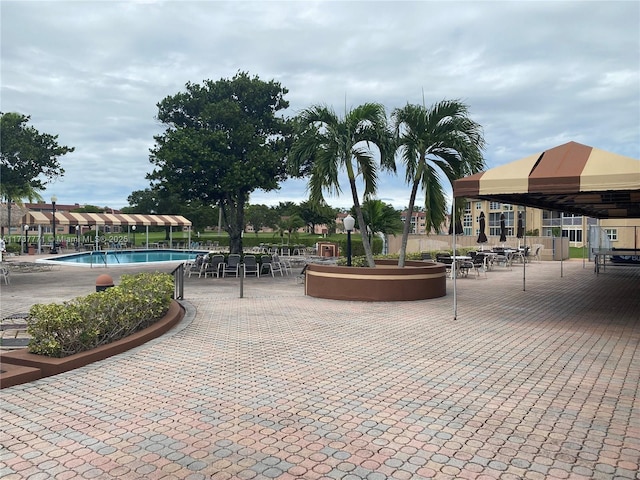 view of community featuring a gazebo, a swimming pool, and a patio area