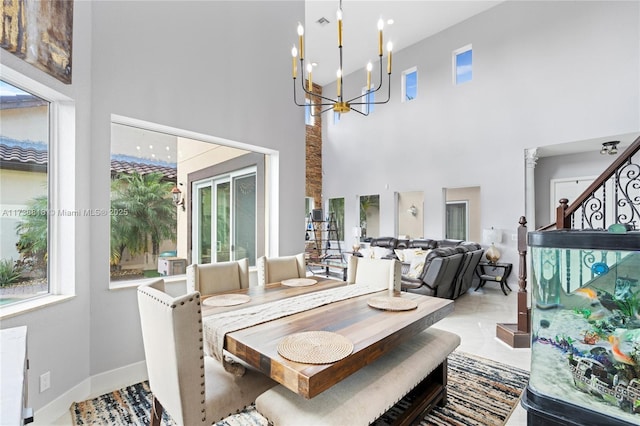 dining room featuring a high ceiling, plenty of natural light, and an inviting chandelier