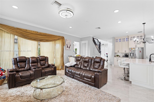 living room with ornamental molding, sink, and a notable chandelier