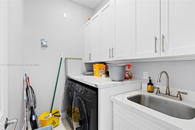 washroom featuring cabinets, washer and dryer, and sink