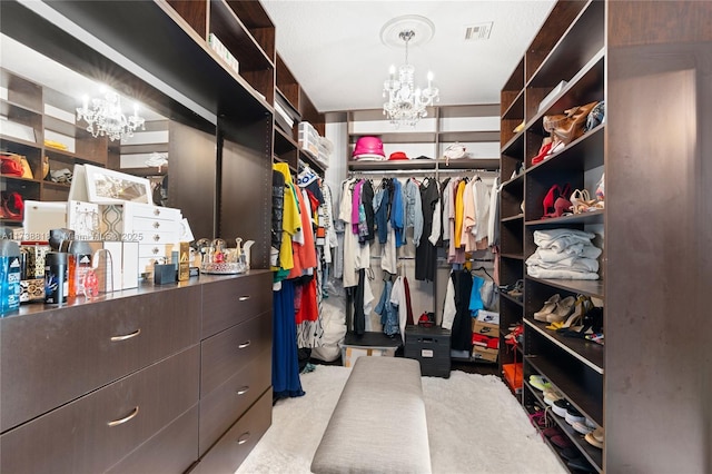 walk in closet featuring light colored carpet and a chandelier