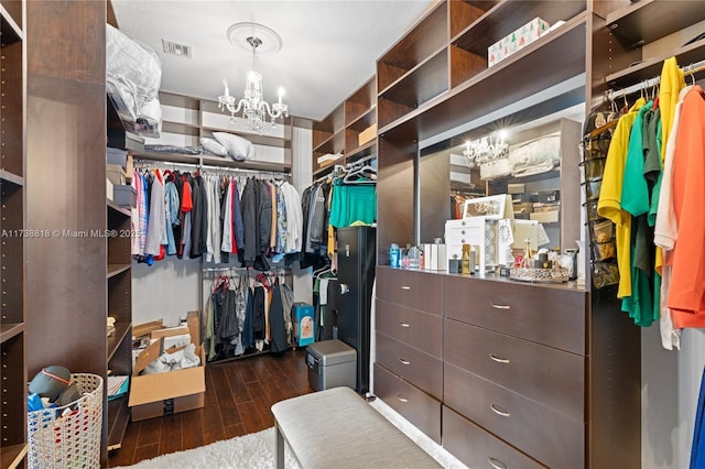 walk in closet featuring a notable chandelier