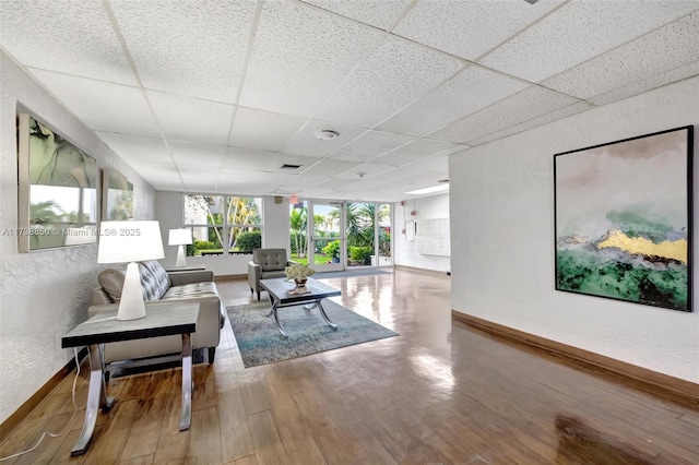 living room with hardwood / wood-style floors and a drop ceiling