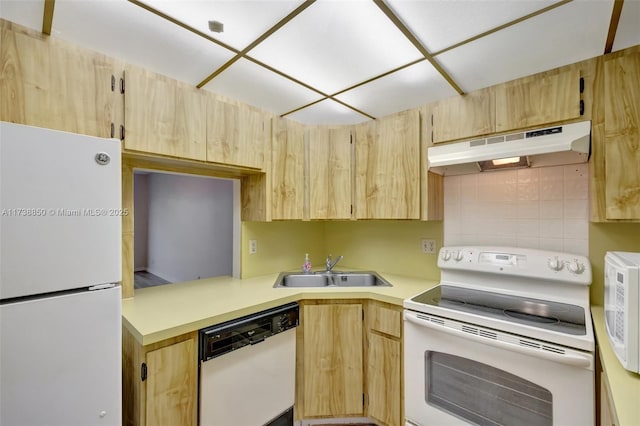 kitchen with light brown cabinetry, sink, and white appliances