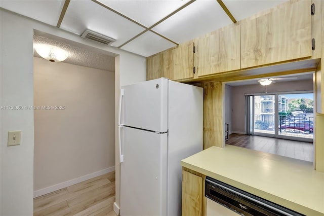 kitchen with dishwasher, light hardwood / wood-style floors, white fridge, and light brown cabinets