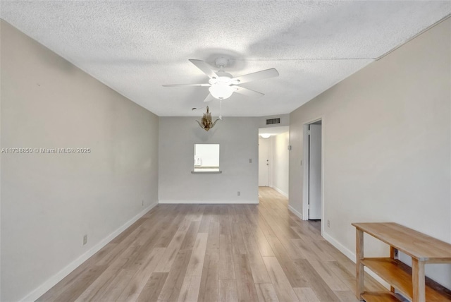 empty room with ceiling fan, a textured ceiling, and light hardwood / wood-style floors