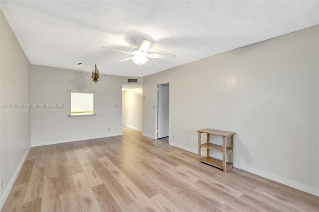 spare room with ceiling fan, light hardwood / wood-style flooring, and a textured ceiling