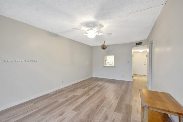 unfurnished room with ceiling fan, light hardwood / wood-style flooring, and a textured ceiling