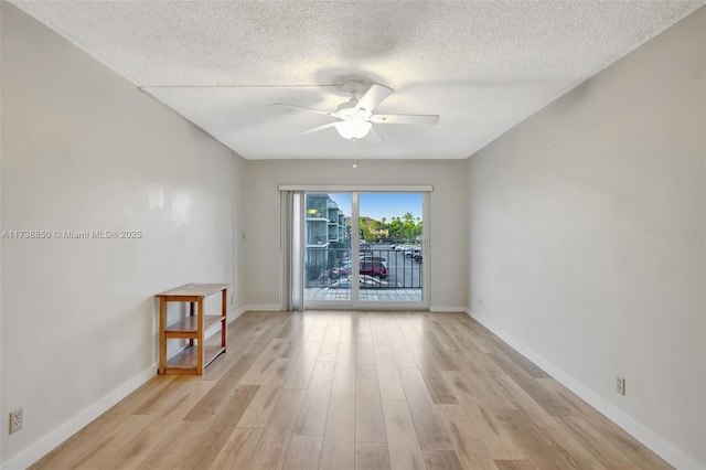 unfurnished room featuring a textured ceiling, ceiling fan, and light wood-type flooring