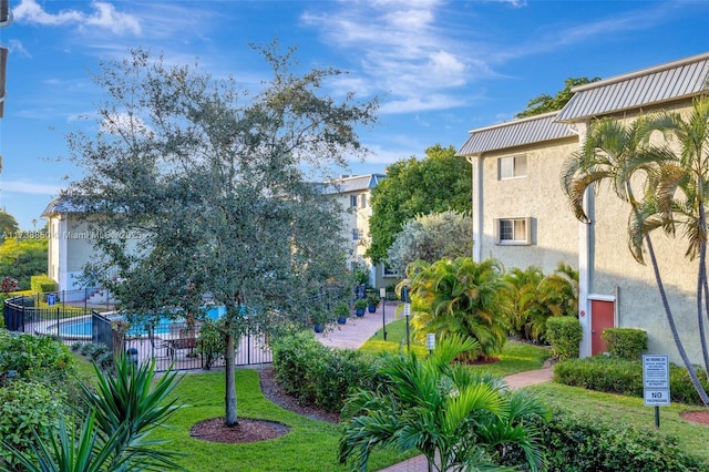 view of community featuring a swimming pool and a lawn