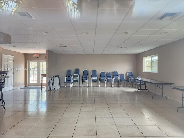 interior space featuring light tile patterned flooring, a paneled ceiling, and french doors