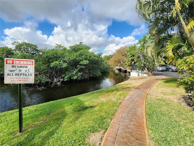 view of community with a water view and a yard