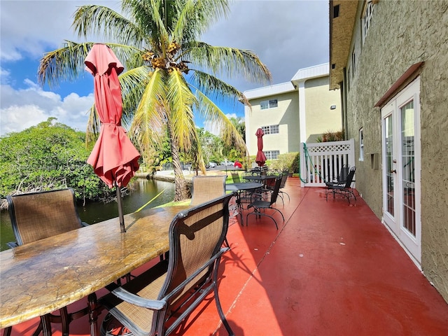 view of patio featuring a water view, a bar, and french doors