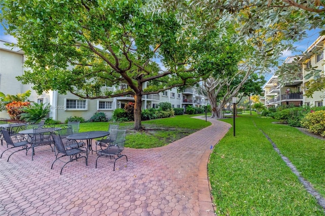 view of home's community with a patio area and a lawn