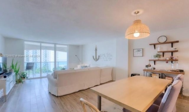 dining area with floor to ceiling windows and light wood-type flooring