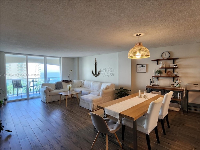 dining space featuring a wall of windows, dark hardwood / wood-style floors, and a textured ceiling