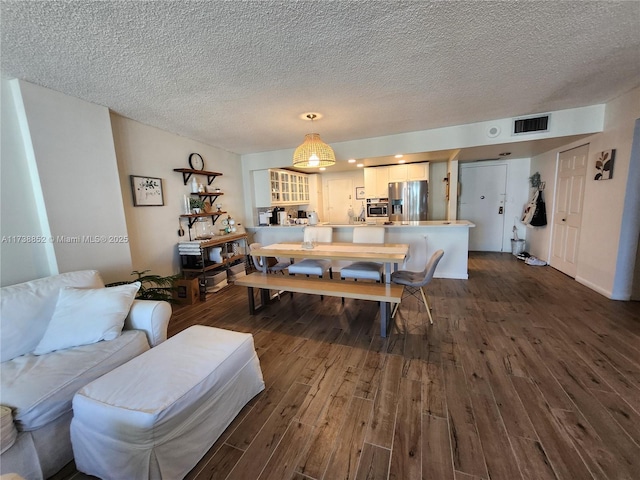 dining area featuring dark hardwood / wood-style floors and a textured ceiling