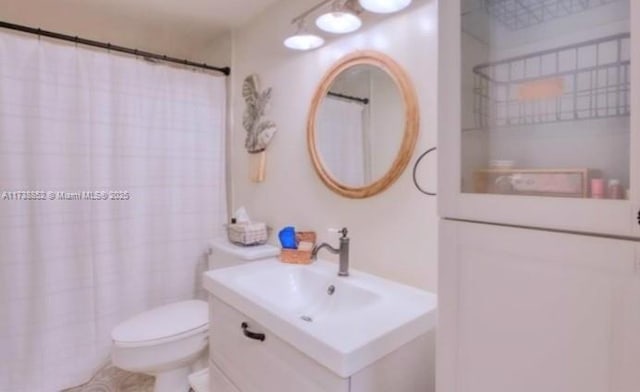 bathroom with vanity, curtained shower, and toilet