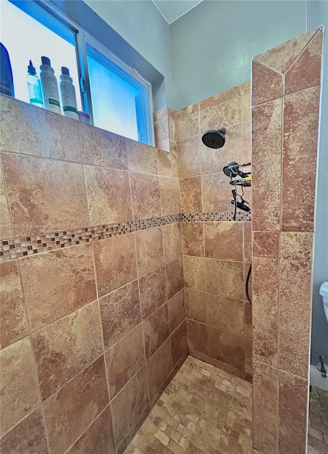 bathroom with tiled shower and toilet