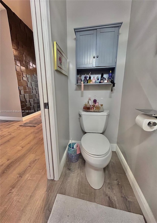 bathroom with hardwood / wood-style flooring and toilet