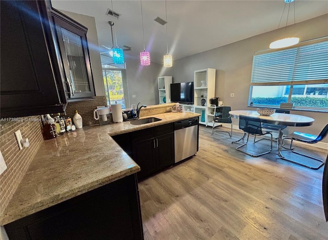 kitchen with sink, stainless steel dishwasher, pendant lighting, and light hardwood / wood-style floors