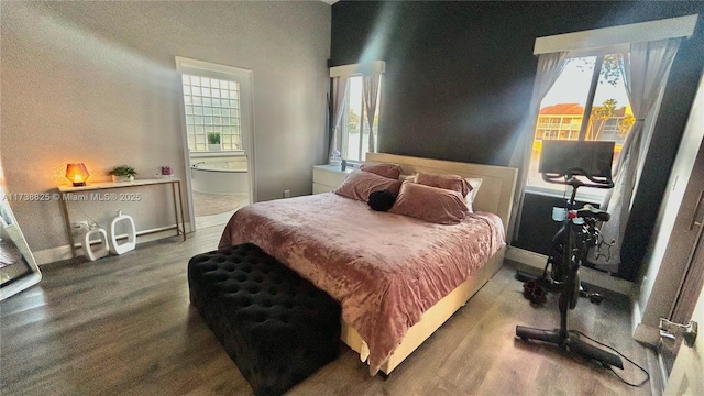 bedroom featuring wood-type flooring and ensuite bath