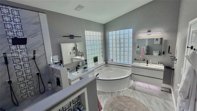 bathroom featuring vanity, vaulted ceiling, and a tub