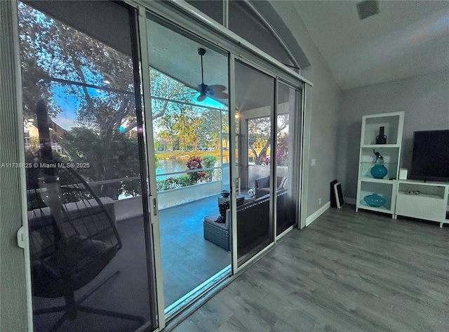 doorway with hardwood / wood-style flooring, ceiling fan, and lofted ceiling