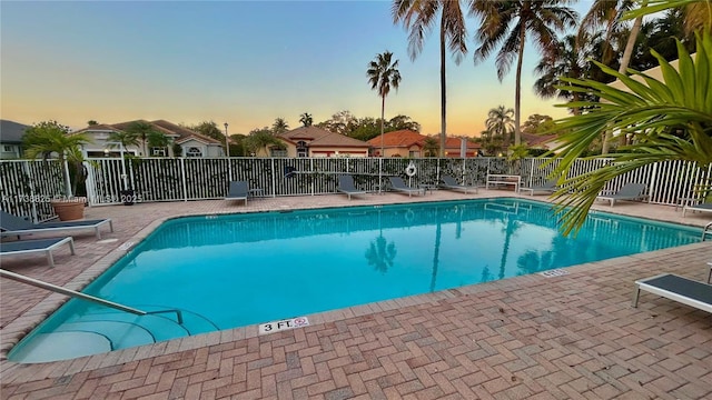 pool at dusk with a patio