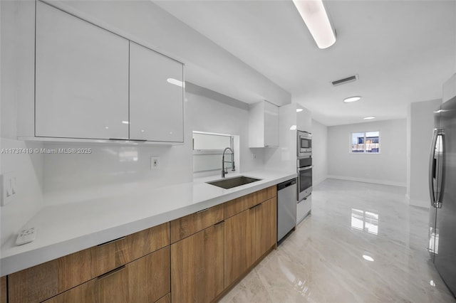 kitchen featuring white cabinetry, sink, and appliances with stainless steel finishes