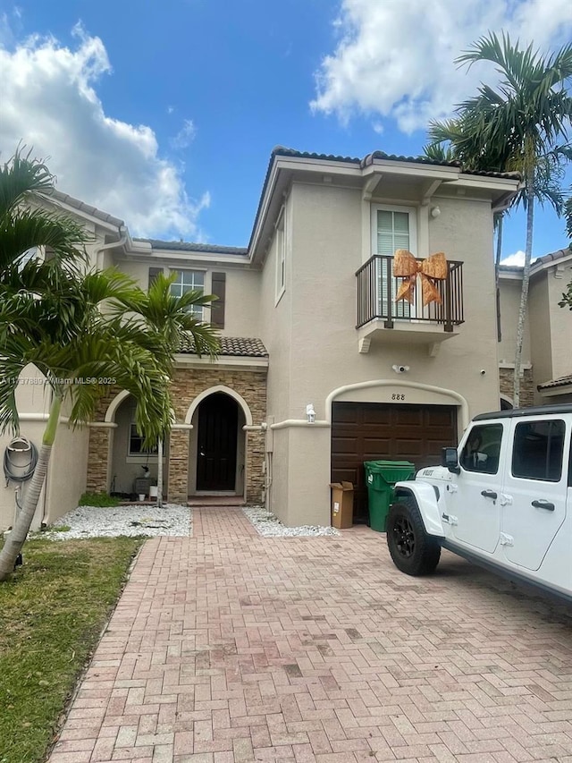 mediterranean / spanish-style house with a garage and a balcony