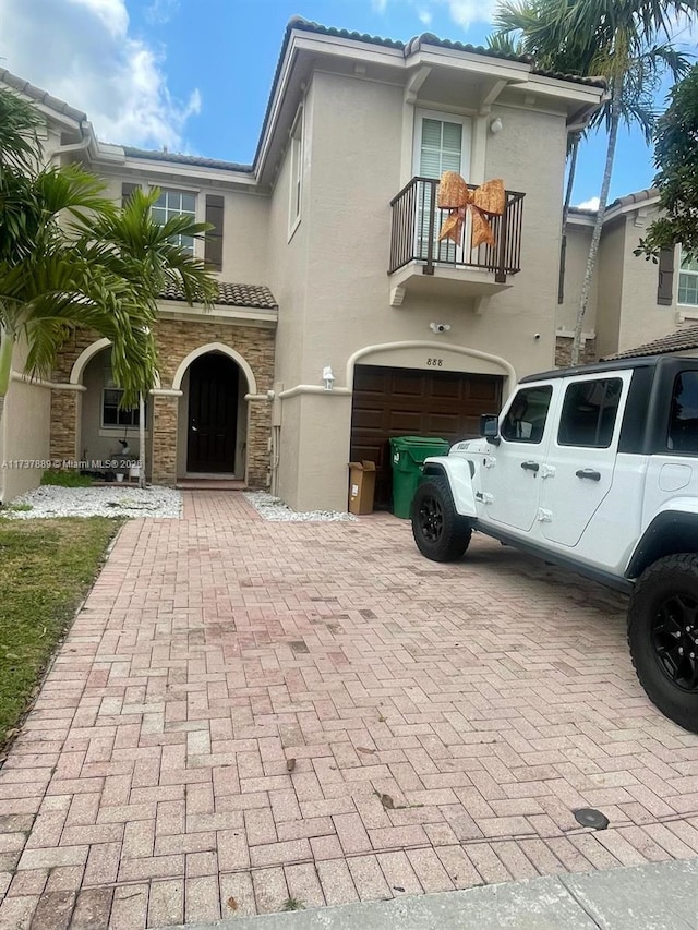 view of front of home with a garage and a balcony