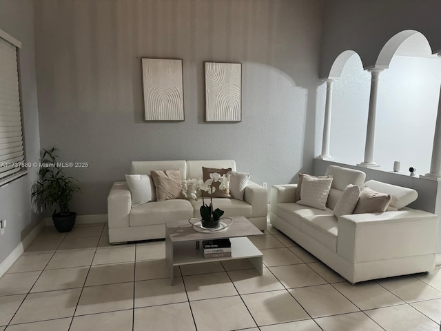 living room with light tile patterned flooring and ornate columns