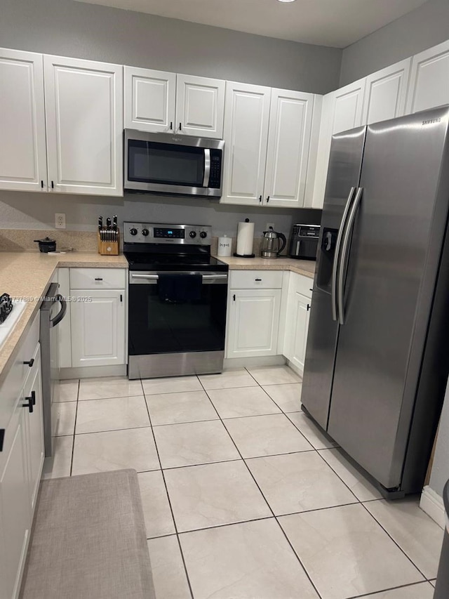 kitchen featuring white cabinetry, appliances with stainless steel finishes, and light tile patterned flooring