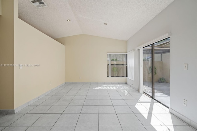 tiled spare room featuring vaulted ceiling and a textured ceiling