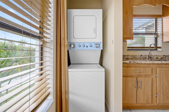 laundry area featuring sink and stacked washing maching and dryer